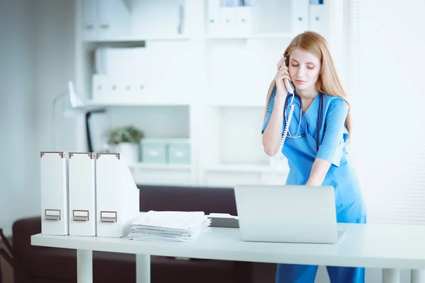 Médica feminina falando por telefone no centro de diagnóstico — Fotografia de Stock