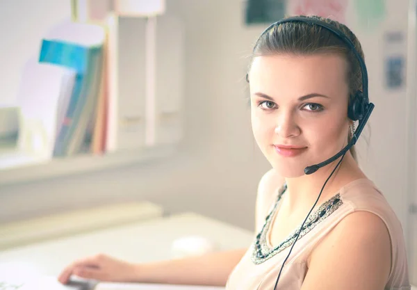 Vacker affärskvinna som arbetar vid sitt skrivbord med headset och laptop — Stockfoto