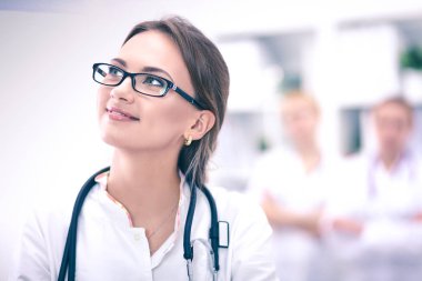 Genç bayan doktor hastanede steteskopla dikiliyor.