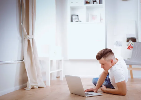 Jonge zakenman, werkzaam in kantoor zittend op de vloer — Stockfoto