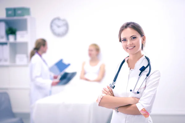 Mladá žena lékař stojící v nemocnici s lékařským stetoskopem — Stock fotografie