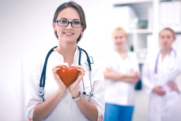 Доктор со стетоскопом держит сердце, изолированное на белом фоне — стоковое фото