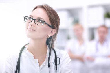 Genç bayan doktor hastanede steteskopla dikiliyor.