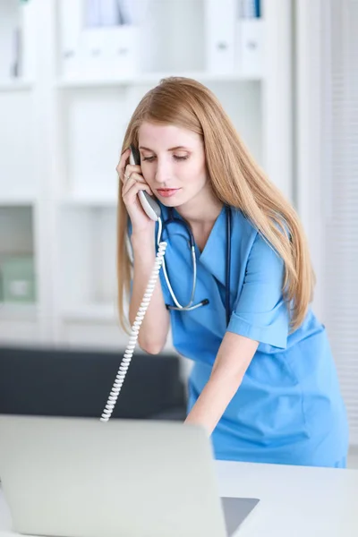 Female doctor talking on phone in diagnostic center — Stock Photo, Image