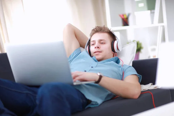 Young man sitting on chair with laptop — Stock Photo, Image