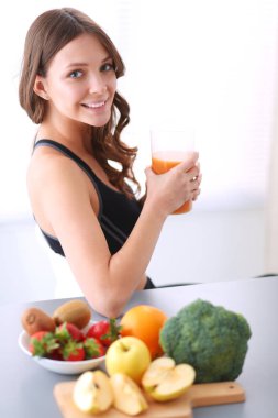 Resepsiyon ile meyve ve meyve suyu ile gözlük mutfakta oturan kız.