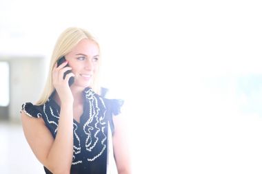 Ofiste cep telefonu kullanan güzel bir iş kadını. .