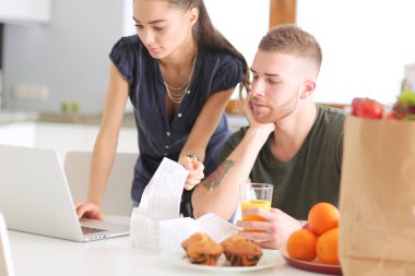 Çift evde mutfak içinde laptop ile onların fatura ödeme