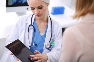 Doktor ve hasta masada otururken bir şey tartışıyorlar. Tıp ve sağlık hizmetleri kavramı. Doktor ve hasta.