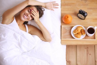 Genç ve güzel bir kadın yatakta yatıyor..