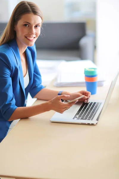 Frau sitzt mit Laptop am Schreibtisch. — Stockfoto