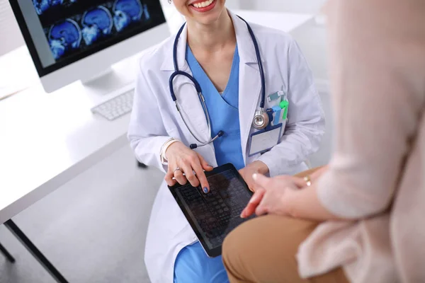 Doktorn och patienten diskuterar något när de sitter vid bordet. Medicin och hälsovård koncept. Läkare och patient — Stockfoto