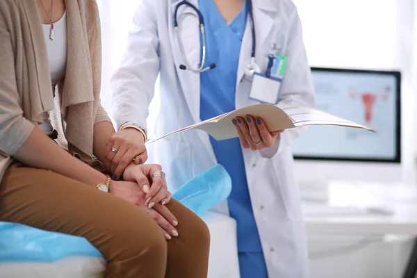 Dokter en patiënt bespreken iets terwijl ze aan tafel zitten. Geneeskunde en gezondheidszorg. Dokter en patiënt — Stockfoto