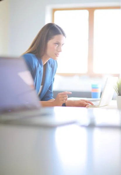 Frau sitzt mit Laptop am Schreibtisch. — Stockfoto