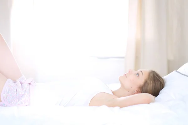 편안하고 행복하게 침대에 누워 있는 아름다운 아가씨. — 스톡 사진