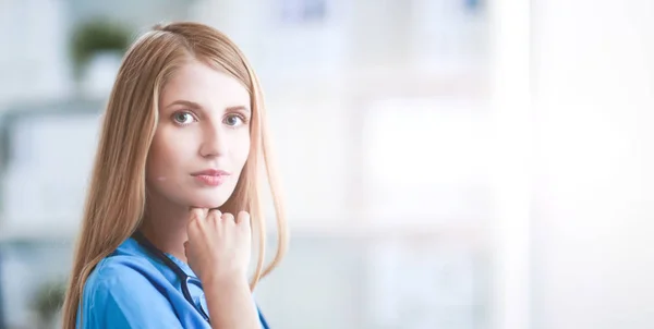 Doctor woman is standing in the near window — Stock Photo, Image