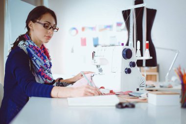 Çalışırken dikiş diken genç bir kadın. .