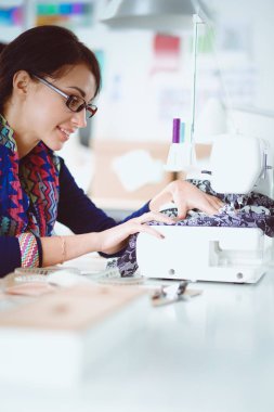 Çalışırken dikiş diken genç bir kadın. .