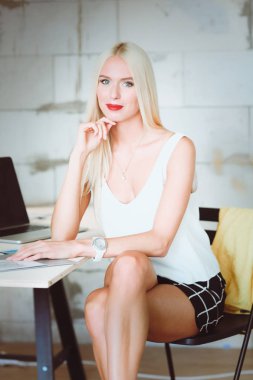 Moda tasarımcıları stüdyoda çalışıyor. Masanın üzerinde oturuyorlar..