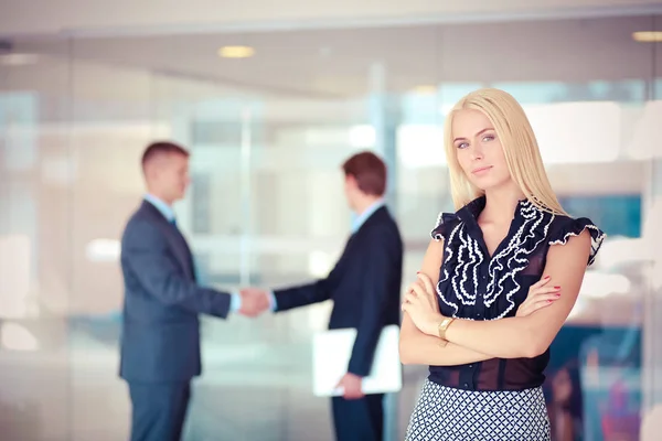 Zakenvrouw permanent op voorgrond in office . — Stockfoto