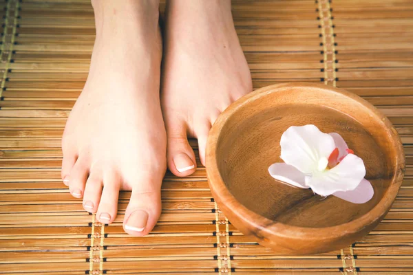 Pflege für schöne Frauenbeine mit Blüte. schöne Frauenbeine — Stockfoto