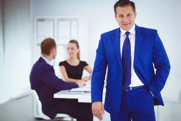 Porträtt av en vacker affärskvinna står i office med kollegor . — Stockfoto