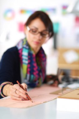 Giysi tasarımcısı kağıt üzerinde kıyafet deseni tasarlıyor .