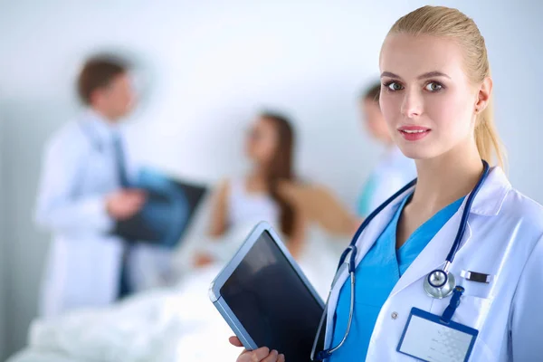 Woman doctor standing with folder at hospital — Stock Photo, Image