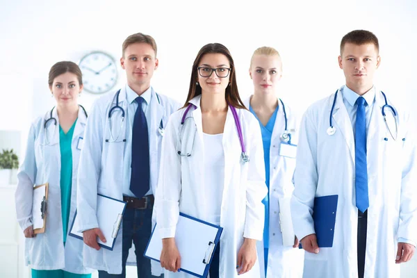 Birlikte ayakta duran bir grup gülümseyen hastane arkadaşının portresi.