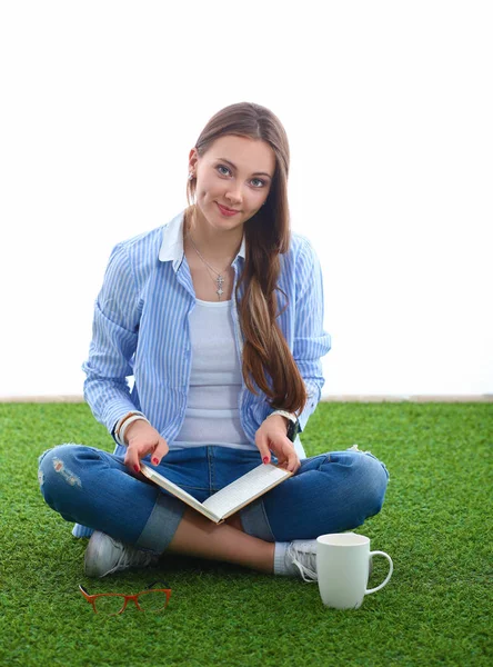 Young woman sitting with book on grass — Stock Photo, Image