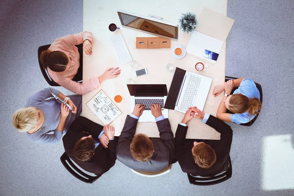 İş adamları iş toplantısında, ofiste oturup tartışıyorlar.