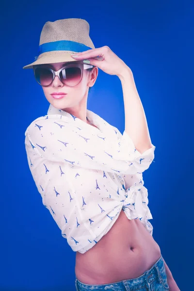 Ritratto di bel modello in cappello con occhiali, isolato su sfondo blu — Foto Stock