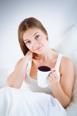 Genç ve güzel bir kadın yatakta oturuyordu .