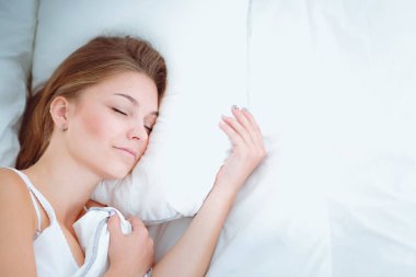 Yatakta rahat ve mutlu bir şekilde yatan güzel bir genç kadın..