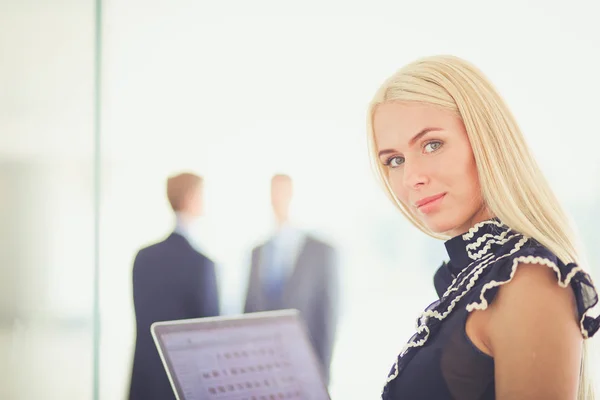 Giovane donna d'affari in possesso di un computer portatile, in piedi su ufficio . — Foto Stock