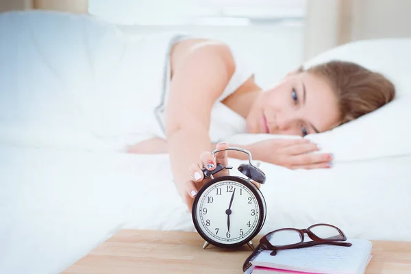 A young woman putting her alarm clock off in the morning. — Stock Photo, Image