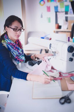 Çalışırken dikiş diken genç bir kadın. .