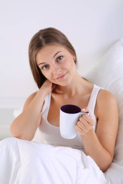 Genç ve güzel bir kadın yatakta oturuyordu .