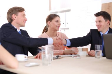 İş adamları iş toplantısında oturup tartışıyor.