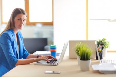 Masada dizüstü bilgisayarı olan kadın.