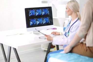 Doktor ve hasta masada otururken bir şey tartışıyorlar. Tıp ve sağlık hizmetleri kavramı. Doktor ve hasta.