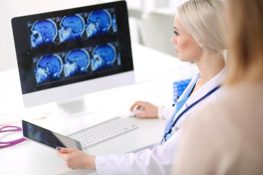 Doktor ve hasta masada otururken bir şey tartışıyorlar. Tıp ve sağlık hizmetleri kavramı. Doktor ve hasta.