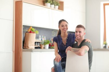 Güzel genç çift evde mutfakta eğleniyor.
