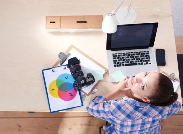 Vrouwelijke fotograaf zitten op het Bureau met de laptop. Vrouwelijke fotograaf — Stockfoto