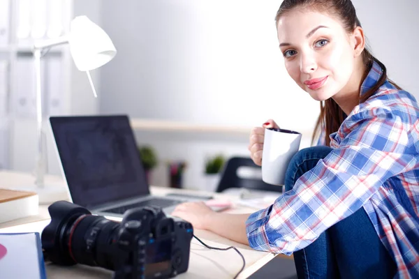 Femme photographe assise sur le bureau avec un ordinateur portable. Femme photographe — Photo