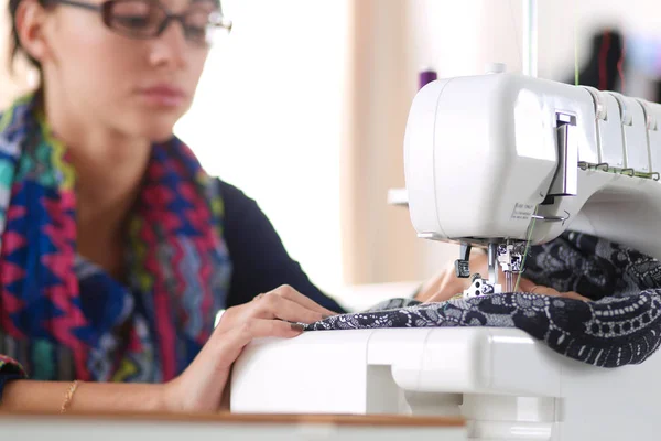 Young woman sewing while sitting at her working place . — Stock Photo, Image