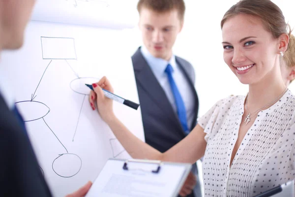 Businesswoman writing on flipchart while giving presentation to colleagues in office . Businesswoman — Stock Photo, Image