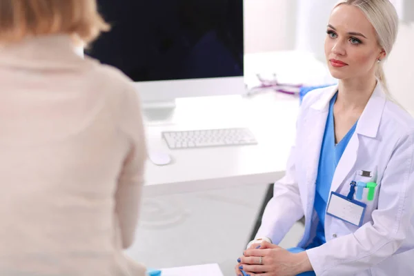 Doktorn och patienten diskuterar något när de sitter vid bordet. Medicin och hälsovård koncept. Läkare och patient — Stockfoto