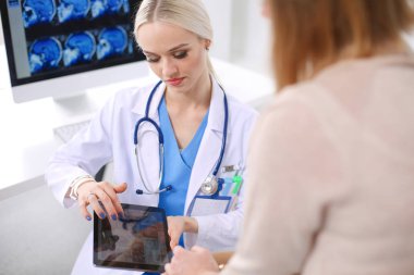 Doktor ve hasta masada otururken bir şey tartışıyorlar. Tıp ve sağlık hizmetleri kavramı. Doktor ve hasta.