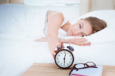 Genç bir kadın sabah alarmını erteliyor..